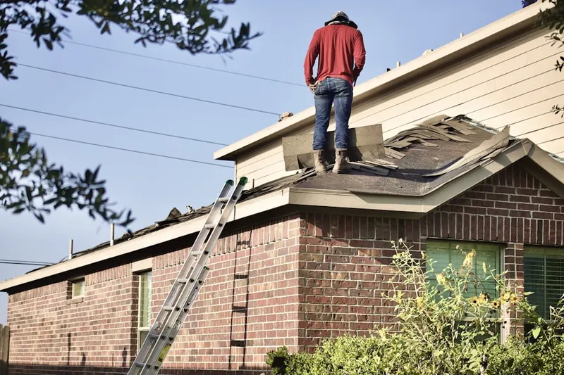 Professional roofer working on a residential roof in Fairways